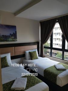 安邦Yeob Bay hotel Ampang的一间卧室设有两张床和大窗户