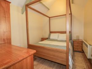 利斯卡德Barn Cottage的一间卧室配有一张四柱床和镜子