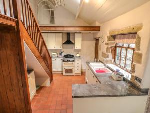 马特洛克Holly Cottage的厨房配有水槽和炉灶 顶部烤箱