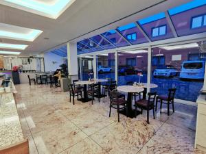 科隆财运酒店的餐厅设有桌椅和窗户。