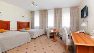 里加Hestia Hotel Draugi的酒店客房设有两张床和一张桌子。