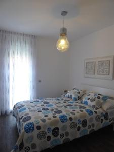 拉拉古纳NORASUITES32的一间卧室配有一张带蓝色和白色棉被的床