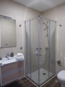 拉拉古纳NORASUITES32的带淋浴、盥洗盆和卫生间的浴室