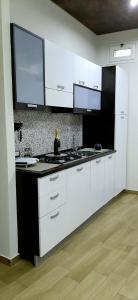 夏卡Castello Apartment Deluxe的厨房配有白色橱柜和黑色台面