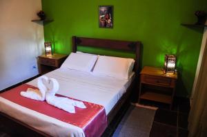 韦尔卡鲍卡斯特拉阿尔沃拉达旅馆的绿色卧室,配有带毛巾的床
