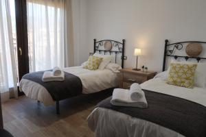 瓜达卢佩MIRADOR DE LAS VILLUERCAS的一间卧室配有两张带毛巾的床