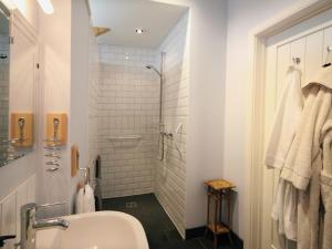 卡林顿Mugwell Barn的带淋浴和盥洗盆的白色浴室