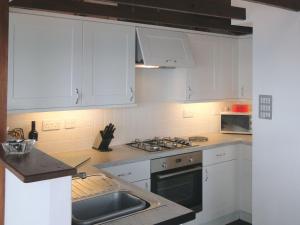 卡桑德Seagulls Nest的厨房配有白色橱柜和水槽