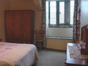 以撒港Tresungers Cottage的一间卧室设有一张床、一个窗口和一把椅子