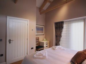 卡林顿Mugwell Barn的卧室配有白色的床和窗户。