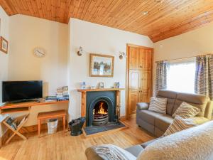 RamsgrangeRose Cottage的客厅设有壁炉和沙发。
