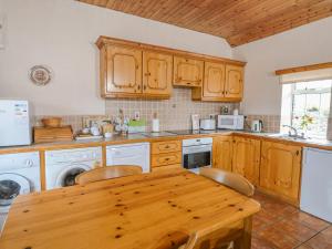 RamsgrangeRose Cottage的厨房配有木制橱柜和木桌。
