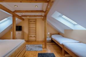 因德日赫城堡Romance Ubytování的阁楼卧室设有两张床和天窗。