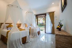 乌布Ubud Batan Nyuh的一间卧室配有两张带白色蚊帐的床