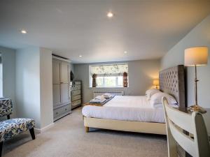 BledingtonThe Granary的卧室设有一张白色大床和一扇窗户。