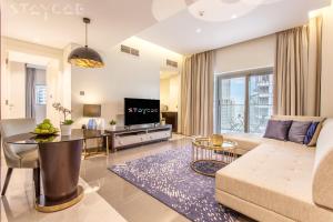 迪拜Staycae Holiday Homes - Majestine的客厅配有沙发和桌子
