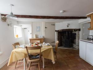 科夫堡Farrier's Lodge的厨房以及带桌子和壁炉的用餐室。