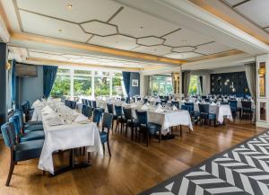 都柏林赫尔伯特山酒店的一间设有白色桌椅的用餐室