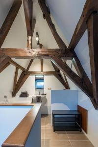 米德尔堡Logement de Spaerpot的阁楼厨房设有木梁和桌子。