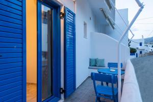 艾丽奇Angeliki Seaside Hotel的一间设有蓝色门的房间,阳台上配有两把椅子