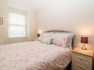 牛顿阿伯特Apartment 18的一间卧室配有一张带粉红色床罩的床