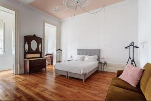 波尔图O da Joana的一间卧室配有一张床、镜子和一张沙发