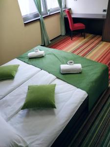 泽尼察Hotel Richi的配有红色椅子的客房内的两张床