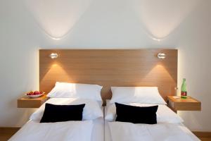 韦尔斯普罗波格酒店的一间卧室设有两张床和木制床头板