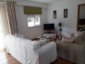 卡武埃鲁Quinta Das Amendoas的客厅配有2张白色沙发和1台电视
