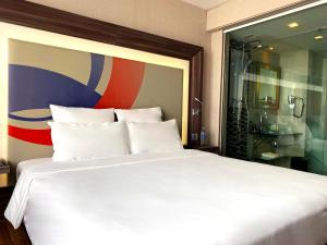 暖武里府曼谷诺富特因帕特酒店的卧室配有一张白色大床和淋浴