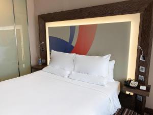 暖武里府曼谷诺富特因帕特酒店的一张带白色枕头的床