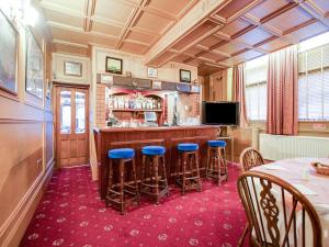 泰恩河畔纽卡斯尔OYO The Rowers Hotel, Dunston Gateshead的厨房设有带蓝色凳子的酒吧