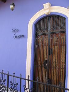 格拉纳达Hotel Casa Cubana Granada Nicaragua的前方有一扇蓝色的墙壁,前方有大门