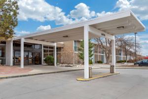 卡农城Quality Inn & Suites Canon City的一座大型白色建筑,设有停车场