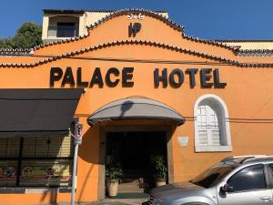 安格拉杜斯雷斯Palace Hotel的一座橙色的建筑,上面有宫殿酒店的标志