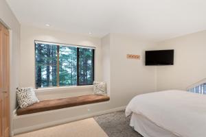 惠斯勒Forest Trails by Whistler Premier的一间卧室设有一张床和一个窗口