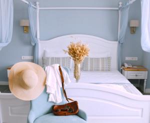 卡斯Luvi Kaş Otel - Adults Only (+16)的卧室配有白色床和椅子上的帽子