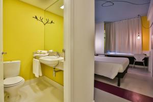贝洛奥里藏特Nobile Inn Pampulha的浴室设有床、卫生间和水槽。