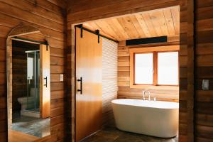 FernwoodBodega Ridge & Cove Cabins的一间带白色浴缸和窗户的浴室