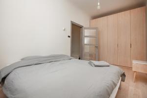 里加Ascetic Skolas Street Apartment的一间卧室配有一张大床和一个木制橱柜