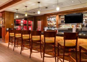 布莱克霍克Lady Luck Casino Black Hawk的餐厅内设有一间带木椅和电视的酒吧