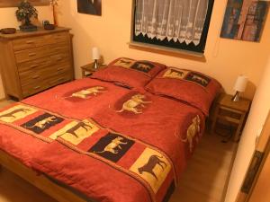 DändorfFerienwohnung Boddenzander的一间卧室配有一张带红色毯子的床