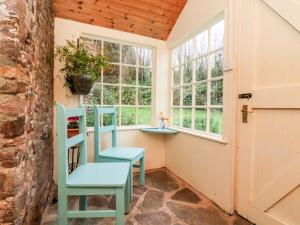 巴恩斯特珀尔Whitefield Cottage的带2把椅子和窗户的房间