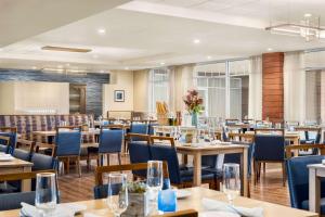 米德尔敦纽波特坎布里亚酒店及会议中心的餐厅设有木桌和蓝色椅子