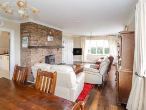伦维尔Clifftop Haven的客厅配有白色家具和砖砌壁炉