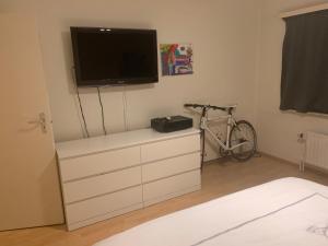 埃德海姆nice and cosy apartment的一间卧室设有梳妆台、电视和自行车