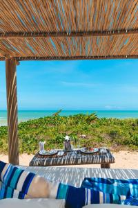 托兰克索Hotel e Resort Villas de Trancoso的海滩上的桌子,享有海景