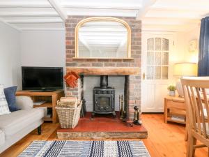 佩文西Fisherman's Cottage的客厅设有砖砌壁炉和电视。