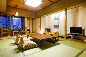 大阪Osaka Ryokan Kuramoto的客厅配有桌椅和电视。