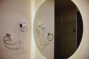 莱昂Departamento con gran diseño cerca de Poliforum的浴室镜子和墙上的吹风机